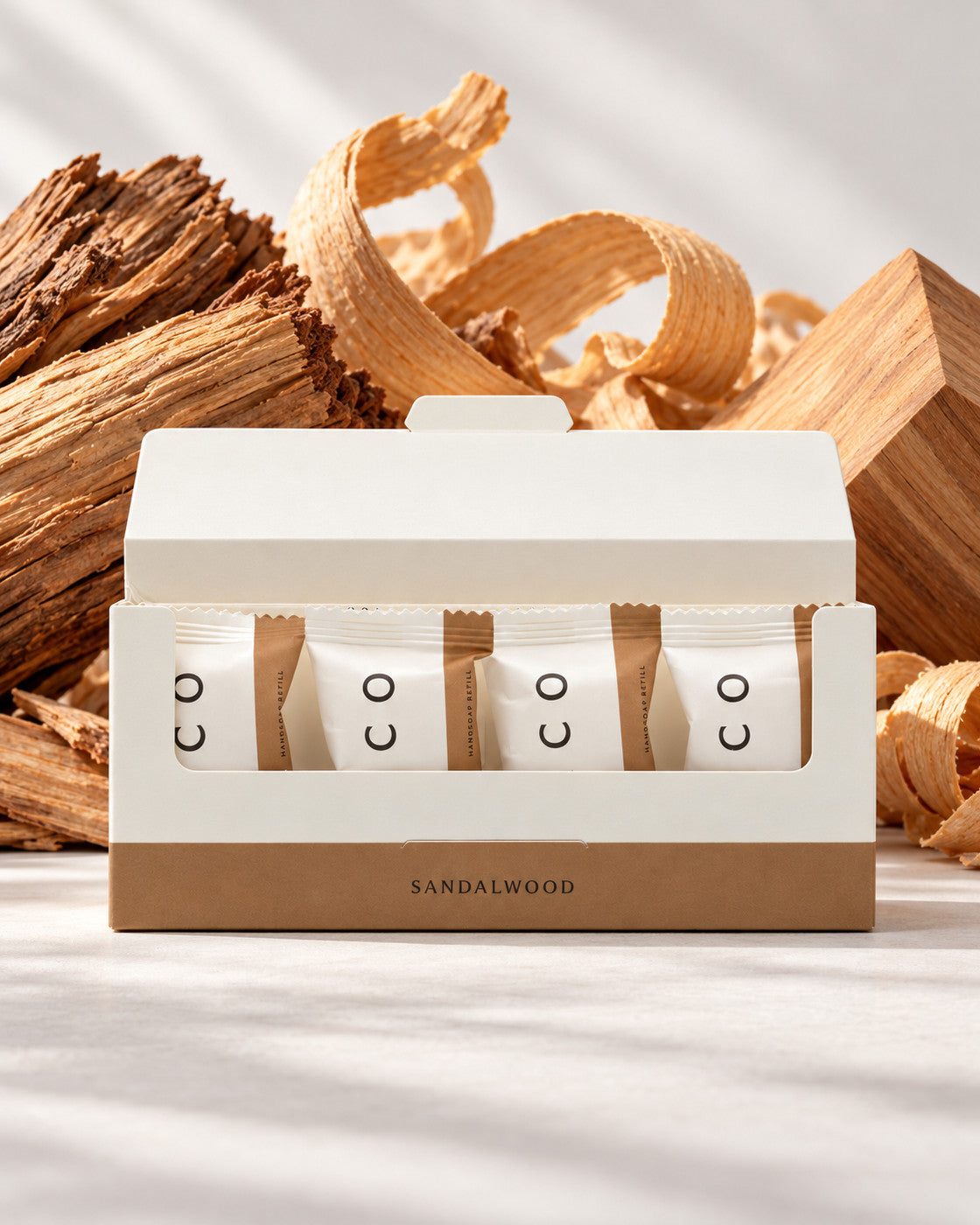 Elico håndsåpe refills 4-pakning Sandalwood, åpen eske med fire refills foran sandeltre og trespon